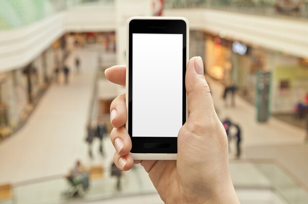 Smartphone with empty screen in woman hand in shopping center