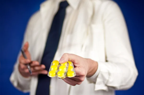 주는 노란 알 약 사용을 설명 하는 의학 의사 스톡 사진