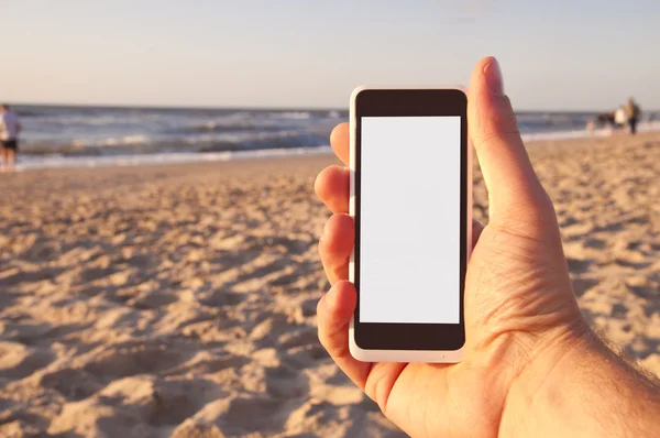 Man with smartphone in his hand on beach. Point of view. — Stock Photo, Image