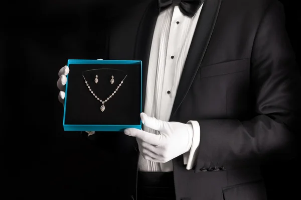 Elegant man in tuxedo presenting jewelery — Stock Photo, Image