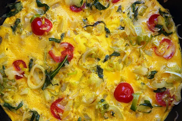 Omelette with tomatoes cherry, leek, paprica and arugula in pan. — Stock Photo, Image