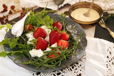Siyah plaka üzerinde eski beyaz dantel masa örtüsü çilek ile.