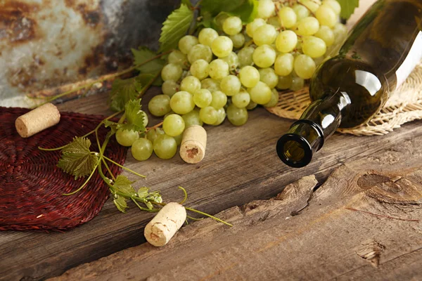 Grappolo verde di uva con bottiglia di vino — Foto Stock