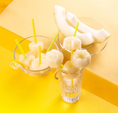 Homemade melon orange fruit sorbet granita popsicles lollies and slices of fresh ripe melon fruit over on yellow background. Top view.  summer dessert, sweet snack. Top view