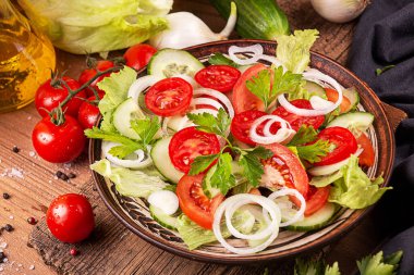 Beyaz soğanlı sebze salatası, salatalık, domates, marul, kırsal arka planda maydanoz. Düşük karbonhidratlı diyet yiyecekler. Üst görünüm