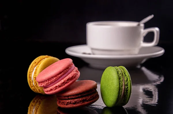 Macarons Coloridos Xícara Café Sobre Fundo Preto — Fotografia de Stock