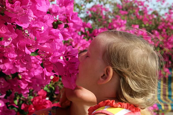 Baby ruikt bloemen — Stockfoto