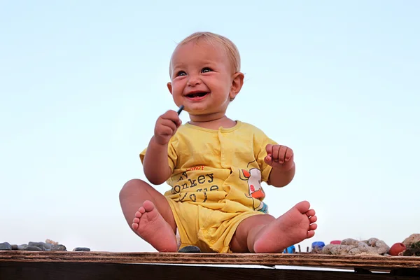 Glimlachend kind zittend op tafel — Stockfoto