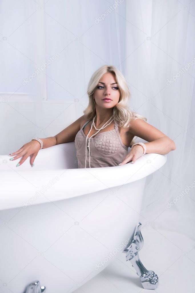 Pretty sexy woman with long blonde hair in bath