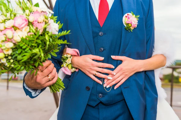 Abraços de noivo noiva com buquê de flores . — Fotografia de Stock