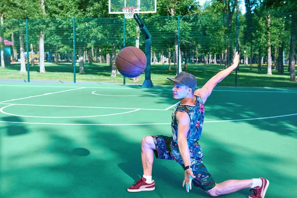 Man met basketbal bal staande op speelplaats Stockfoto