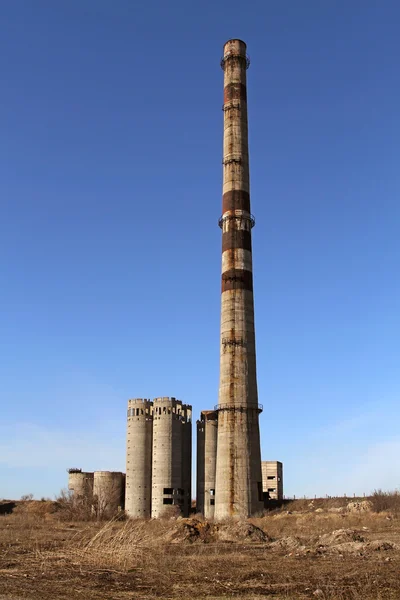 与固定在一个高耸的烟囱被毁坏工厂的废墟 — 图库照片