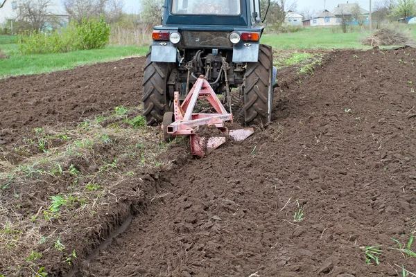 Tractor con campo de arado de resorte abrochado. Cuidado de primavera de t —  Fotos de Stock