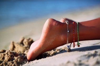 Foot girl lying on the beach clipart