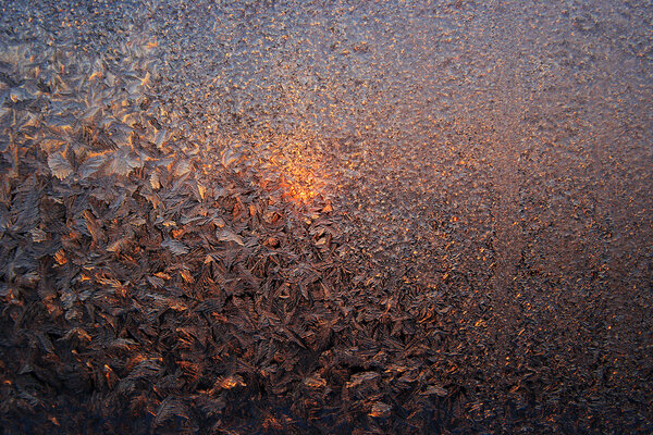 Солнце светит сквозь матовое стекло. Морозный узор на
