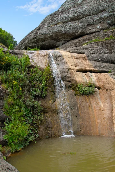 Piccola cascata di montagna che scorre nella ciotola di pietra piena di — Foto Stock