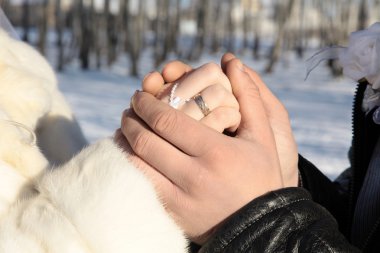 Yakın çekim yakışıklı erkek ve kız. Genç erkek damat elini tutar 