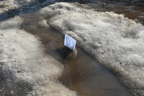 Przez wesoły wiosna creek pływający statek z papieru dla dzieci. — Zdjęcie stockowe