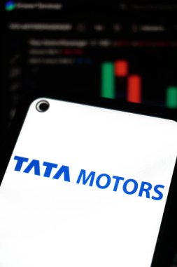 KERALA, INDIA OCT 15, 2025 - Tata Motors logosunu koyu mavi metinde gösteren akıllı telefon ekranı, bulanık finansal tabloya karşı ayarlanmış, borsa ve yatırım bağlamını vurguluyor.