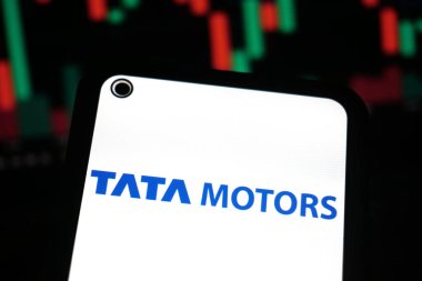 KERALA, INDIA OCT 15, 2025 - Tata Motors logosunu koyu mavi metinde gösteren akıllı telefon ekranı, bulanık finansal tabloya karşı ayarlanmış, borsa ve yatırım bağlamını vurguluyor.