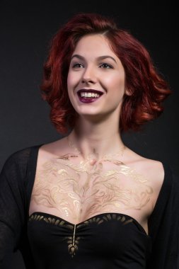 Kızıl saçlı kız siyah bir zemin üzerine vücudunda salatim kalıp ile.