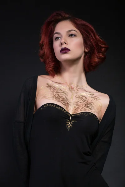 Kızıl saçlı kız siyah bir zemin üzerine vücudunda salatim kalıp ile.
