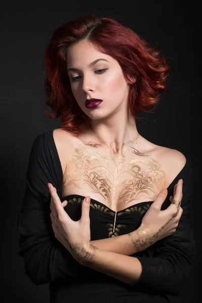 Redhead girl with salatim pattern on the body on a black background. — Stock Photo, Image