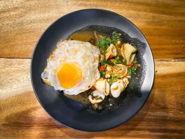 Üzerine kızarmış kalamar ve fesleğen ve sahanda yumurta.