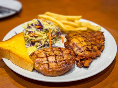 Kızarmış patatesli biftek ve masada salata.