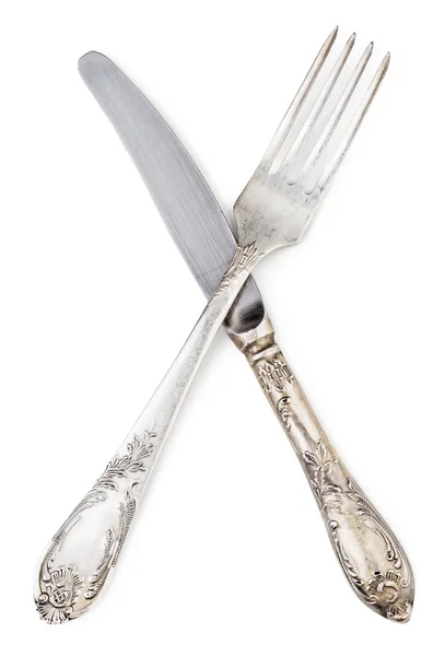 Gamla silver kniv och gaffel korsade isolerade — Stockfoto