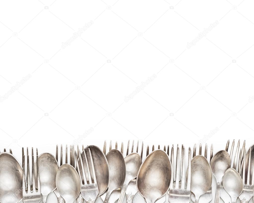 Aged vintage silver forks and spoons border isolated