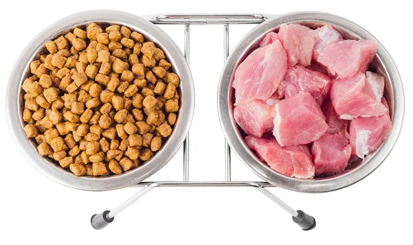 Мясо и сухая пища для домашних животных в металлических мисках — стоковое фото