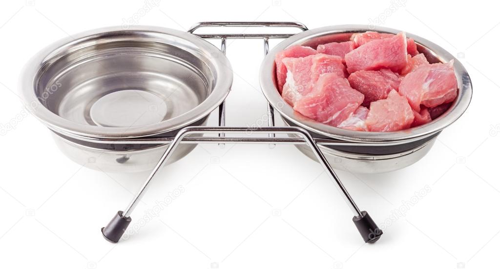 Meat and water for pets in metal bowls isolated