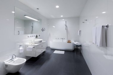 PRAGUE, CZECH REPUBLIC - 10 HAZİRAN 2020: rahat beyaz küvet ve lavabo modern banyo ayakta beyaz duvarlar ve beton zemin. İçi muhteşem oval banyoyla dolu..