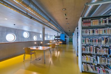 HRADEC KRALOVE, CZECH REPUBLIC - 10 Aralık 2020: Araştırma Kütüphanesi bir devlet üniversitesi kütüphanesidir. Yuvarlak pencereleri ve kitaplıkları olan modern bir iç mekan. Olağanüstü bir beton bina.