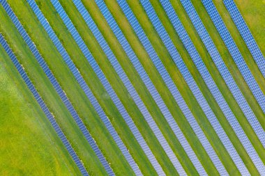 Yeşil alandaki güneş enerjisi santralinin havadan görüntüsü. Temiz ekolojik enerji üretmek için elektrik panelleri. Güneş pili alanı. Megawatt Enerji Santrali Güneşten yenilenebilir enerji.