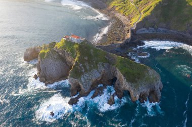 Aerial view of the island and the Gaztelugatxe temple. Northern Spain in summer Manmade way to small isle on the Atlantic shore in Biscay region. Beautiful sunny morning.