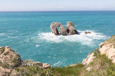 Kuzey İspanya 'da kayalık manzaralı deniz manzarası. Atlantik Okyanusu kıyısı. Güneşli güzel bir gün. Tatil döneminde manzaralı altın kayalıklar ve zümrüt su.