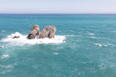 Kuzey İspanya 'da kayalık manzaralı deniz manzarası. Atlantik Okyanusu kıyısı. Güneşli güzel bir gün. Tatil döneminde manzaralı altın kayalıklar ve zümrüt su.