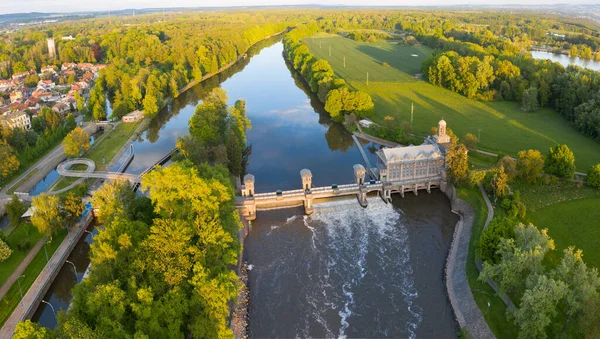 Historical water power plant building with the weir on the Labe River lock in Podebrady, Czech Republic. Aerial view on Old lock chamber in summer sunny color evening. Hydroelectric plant