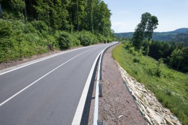 Yeni asfalt yolu ve istinat duvarları. Gökyüzünden güzel güneşli bir yaz günü. Hava görüntüsü.