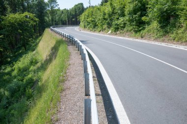 Yeni asfalt yolu ve istinat duvarları. Gökyüzünden güzel güneşli bir yaz günü. Hava görüntüsü.
