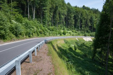 Yeni asfalt yolu ve istinat duvarları. Gökyüzünden güzel güneşli bir yaz günü. Hava görüntüsü.