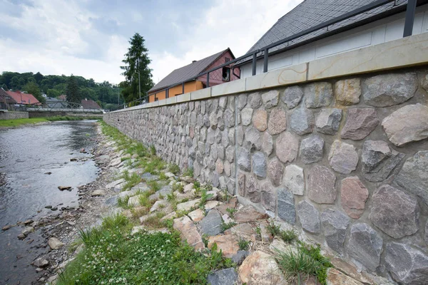 Modern flood protection wall in the style of the historic city wall. Permanent measures against floods. gate valves and walls. Flood gates protecting city against flooding from stream.