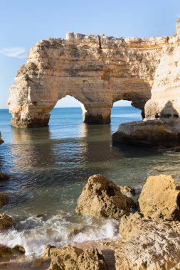 Algarve, Portekiz sahillerinde güneşli bir gün. Arkasında turkuaz deniz var. Algarve kayalıklarının kuş bakışı görüntüsü. Hava görüntüsü. Portekiz 'de seyahat kavramı ve Portekiz' deki en güzel yerler..