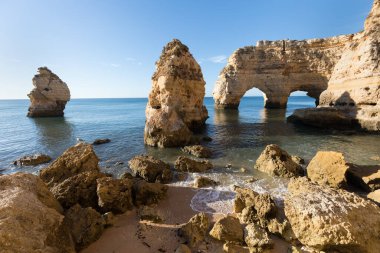 Algarve, Portekiz sahillerinde güneşli bir gün. Arkasında turkuaz deniz var. Algarve kayalıklarının kuş bakışı görüntüsü. Hava görüntüsü. Portekiz 'de seyahat kavramı ve Portekiz' deki en güzel yerler..