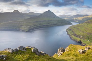 Faroe Adaları 'nın tepesinde. Güneşli bir günde yüksek dağ zirveleri manzarası. Okyanus manzaralı. Güzel panoramik manzara. Kuzey Avrupa. Seyahat kavramı