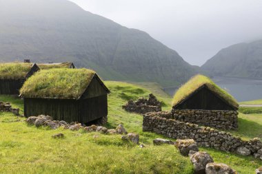 Tipik çim çatılı evler için güneşli bir sabah manzarası. Danimarka 'nın Streymoy Adası' nın panoramik yaz manzarası. Torshavn Faroe Adaları, Danimarka Krallığı, Avrupa. Seyahat konsepti arka planı.