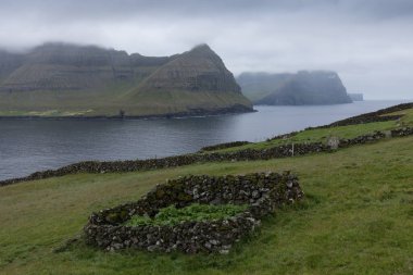 Faroe Adaları 'nın tepesinde. Güneşli bir günde yüksek dağ zirveleri manzarası. Okyanus manzaralı. Güzel panoramik manzara. Kuzey Avrupa. Seyahat kavramı
