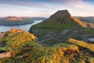 Faroe Adaları 'nın tepesinde. Güneşli bir günde yüksek dağ zirveleri manzarası. Okyanus manzaralı. Güzel panoramik manzara. Kuzey Avrupa. Seyahat kavramı